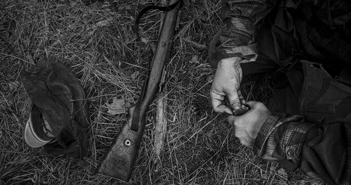 German Soldier hands reloading Mauser rifle with stripper clip during battle simulation