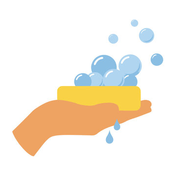 Hand holding soap with bubbles and water drops