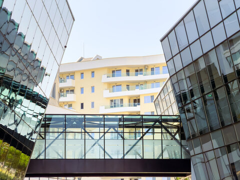 Modern buildings connected by a bridge in a city setting during daylight hours