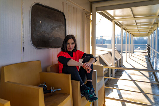 Woman in red shirt resting on a ferry deck in sunlight