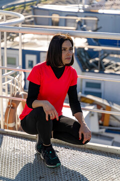 Athletic woman in sportswear taking a break, looking away at the harbor
