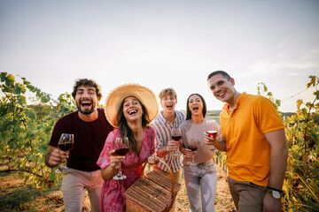 Obraz premium Cheering friends shouting with joy holding wine glasses in vineyard