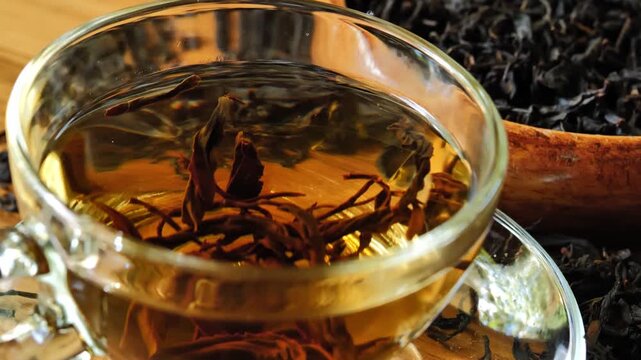 Hot tea in a clear glass cup on a wooden table	