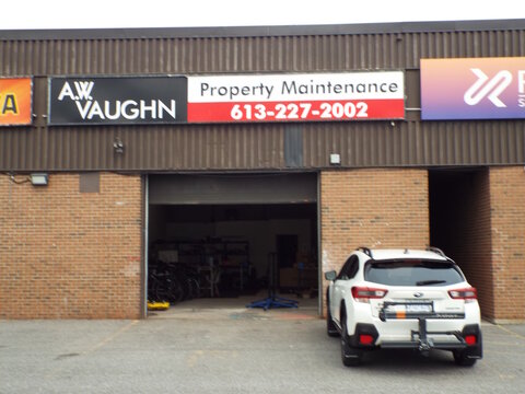 Gloucester, Ontario, Canada &ndash; July 23, 2026: The "A.W. Vaughn Property Maintenance" storefront features a black and white company sign above an open garage bay with a parked white car at 5370 Canotek 