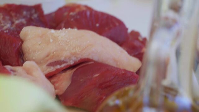 Close-up of large raw meat pieces for pilaf on a plate
