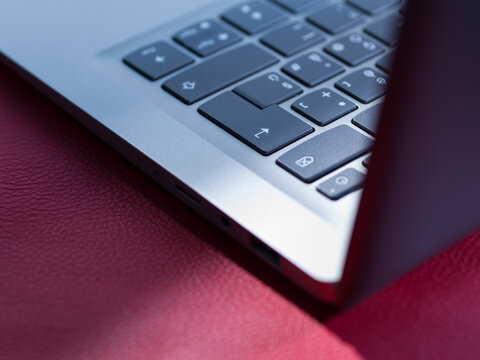 Laptop Keyboard and Edge Corner Macro on Red Textured Background