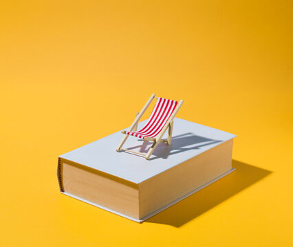 Miniature Beach Chair on Book for Summer Holiday Reading Concept