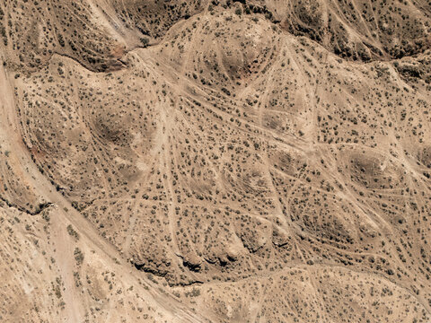 Aerial view of barren desert hills and rugged terrain landscape
