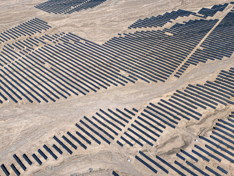 Aerial view of solar panel arrays in desert landscape