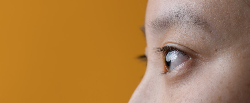 Macro Close-Up of Young Asian Woman's Eye and Natural Freckled Skin