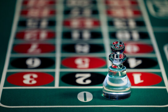Glass dolly marker placed on zero field on classic vintage roulette table. Image shows casino nightlife entertainment, winning bet results, and high stakes risk.