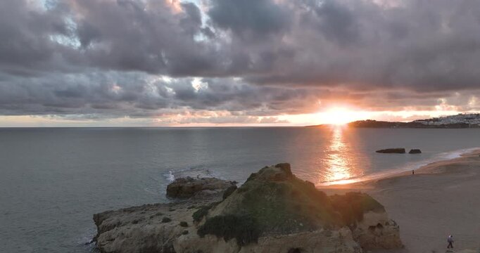 Sunset over golden cliffs and sandy beach in Albufeira Algarve
