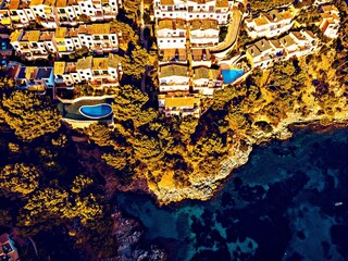 Obraz premium Aerial view of coastal villas with swimming pools and ocean
