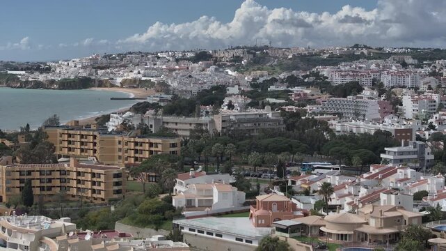 Flyover of whitewashed Albufeira and Praia dos Pescadores beach