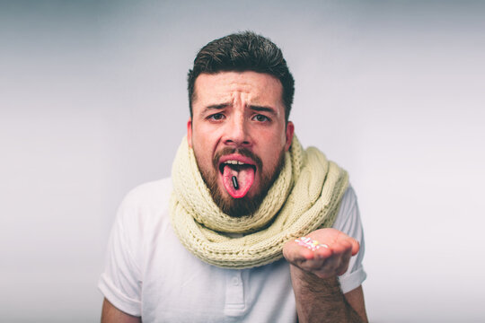 tablet on the tongue of a bearded guy