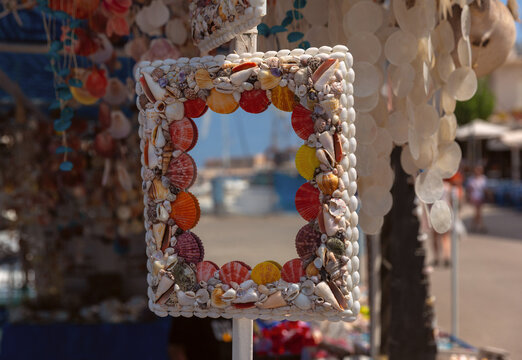 Decorative mirror covered with colorful seashells displayed at a souvenir stall in Chania, Crete, Greece.