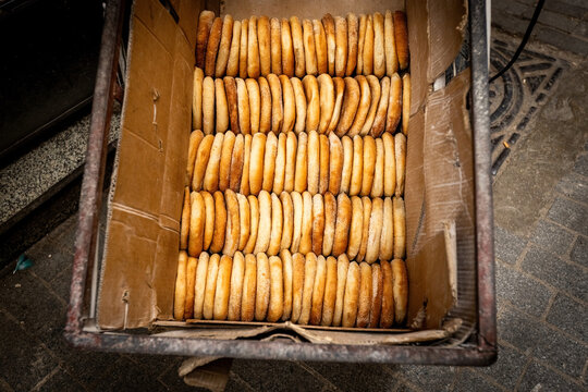 A large stack of traditional Moroccan semolina biscuits (fekkas) displayed in neat rows on a market stall in the medina of Fez, Morocco