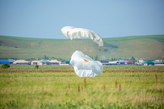 Skydiving. Flying parachutists against the background of the blue sky and mountains. Extreme sport and entertainment.