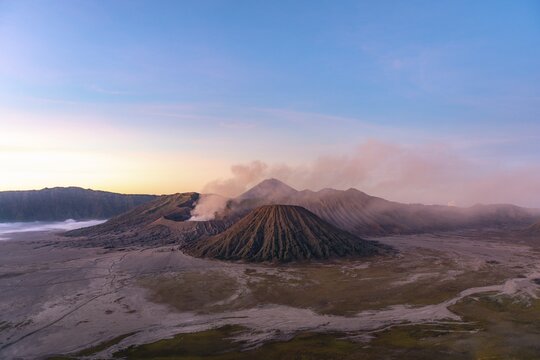 Volcanic landscape at sunrise, smoking volcano Gunung Bromo, with Mt. Batok, Mt. Kursi, Mt. Gunung Semeru, Bromo-Tengger-Semeru National Park, Java, Indonesia