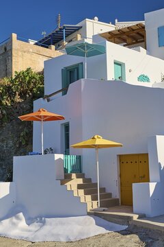 White house with colorful umbrellas and stairs in Mediterranean surroundings, Syrmata, boat garages, boathouse, boathouses, beach house, Goupa, Goypa, Goupa Kara, Kimolos, Cyclades, Greek Islands, Greece