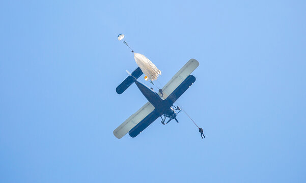 Skydiving. Parachutists jump from a flying plane in the air. Extreme sport and entertainment.