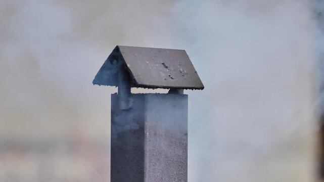 Chimney expelling smoke, a rural farm building showing air pollution from burning wood