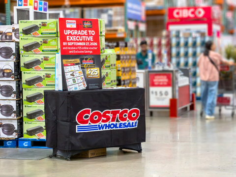 Calgary, Alberta, Canada. September 27, 2026. Promotional membership upgrade display table inside a Costco wholesale warehouse store with shoppers.