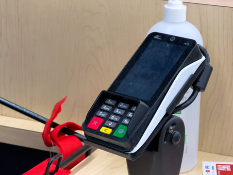 Calgary, Alberta, Canada. September 27, 2026. Close-up of a contactless payment terminal and keypad mounted on a retail counter stand.