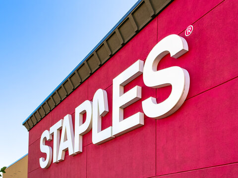 Calgary, Alberta, Canada. September 27, 2026. Low-angle close-up exterior view of the Staples retail store sign against a red wall.