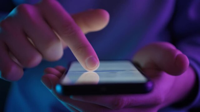Fingers scrolling on a smartphone screen with neon lighting and bokeh effect