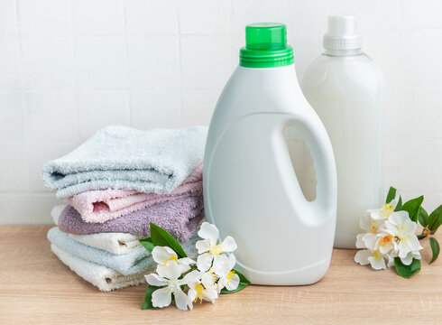 Detergent and fabric softener with fresh laundry towels and flowers
