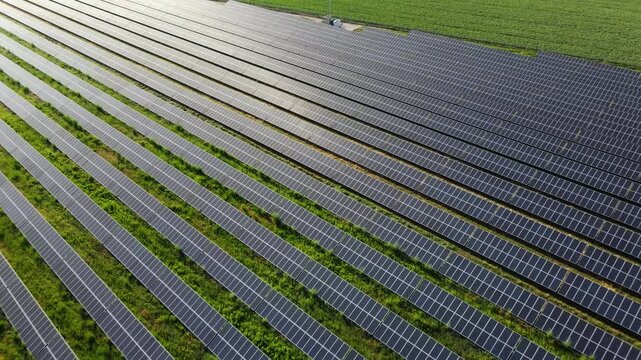 Drone flying over a large solar farm with photovoltaic panels. Clean and sustainable energy production from sunlight in a rural landscape