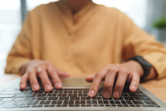 Person typing on a laptop while working at a desk. Digital research and online communication support journalism, freelance writing, editing and media production.