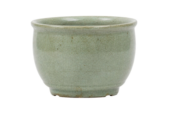 Antique celadon ceramic tea cup with a delicate crackled glaze texture, captured on a clean white background
