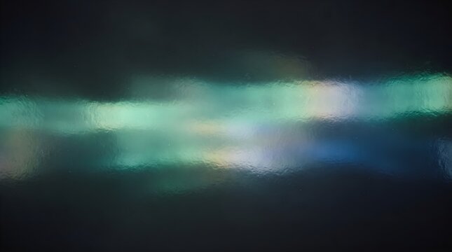 Colorful light refracted through a textured surface, producing soft blue, green, and warm highlights in an abstract luminous composition.