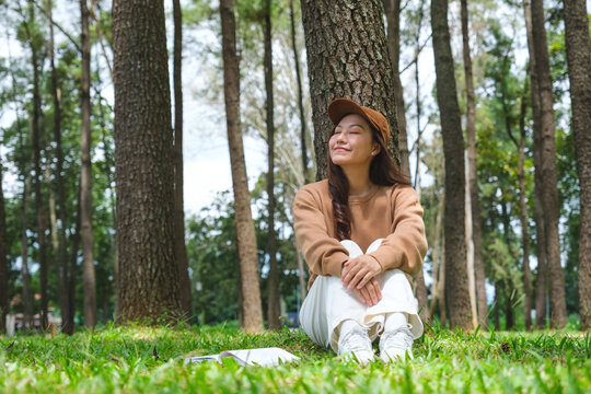 Portrait image of a woman with a book sitting in the park