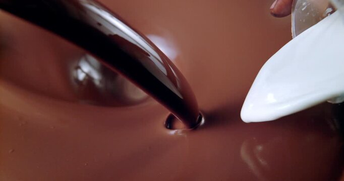 Creamy chocolate liquid swirling with milk in slow motion macro shot