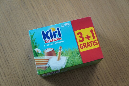 A box of Kiri Przekaska cheese snack with breadsticks on a wooden table surface for a snack