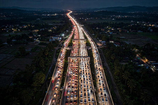 Aerial night view of a congested Indonesian toll road full of car headlights during Eid mudik homecoming