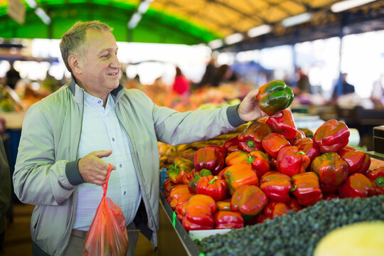 Middle aged man buying peppers