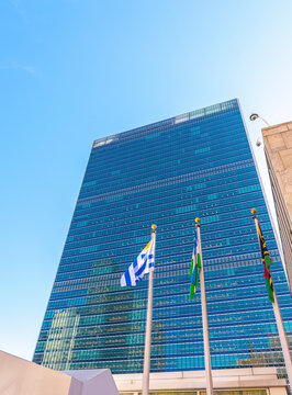 United Nations building facade with flags under a blue sky in New York