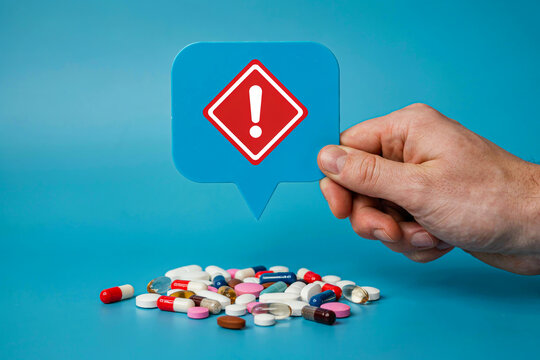 Medication warning sign with pills and capsules photo illustration   