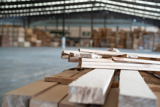 Stacked lumber inside the timber warehouse forms closely packed layers, with the ends of individual wooden planks visible.