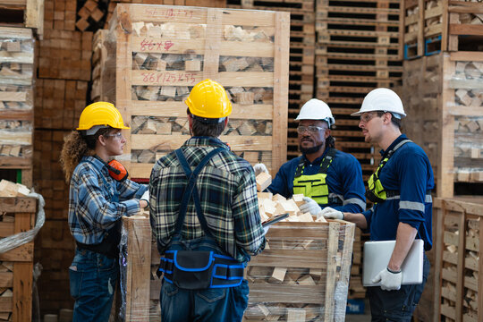 Workers check wood offcut quality in a crate as four colleagues discuss the pieces beside a laptop and clipboard.