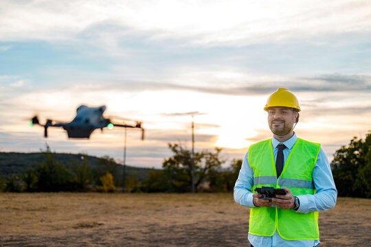 Drone pilot flies UAV at sunset with safety gear and remote control