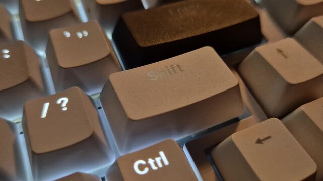 Close up of glowing backlit computer keyboard keys with breathing LED light effect