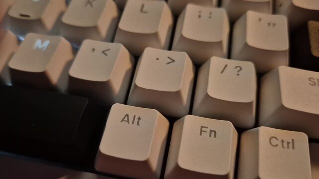 Close up of glowing backlit computer keyboard keys with breathing LED light effect