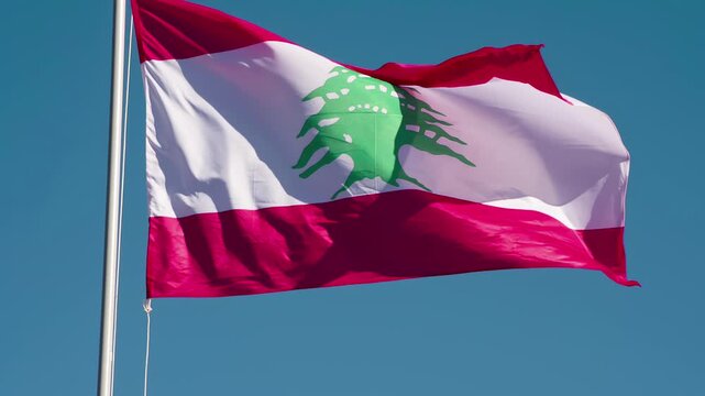 Lebanese Flag Waves the Wind. The Big State Flag is illuminated by the sun and flutters epically in the wind against the blue sky