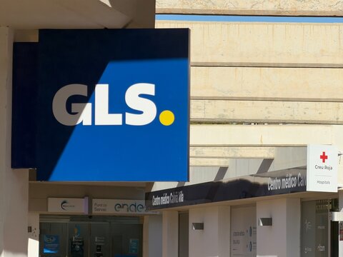 Mallorca, spain, septiembre 18, 2026 gls parcel service sign on a commercial building facade with a medical center, avinguda pere vaquer, calvia, spain