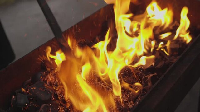 Blacksmith forge flames intensify over glowing coals inside rugged metal workshop basin